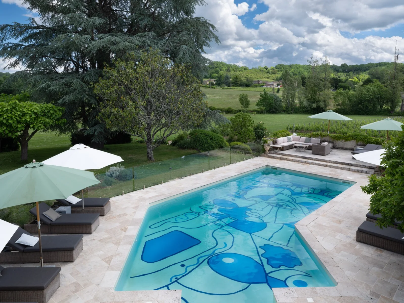 Piscine extérieure du Palanquey avec son fond artistique bleu