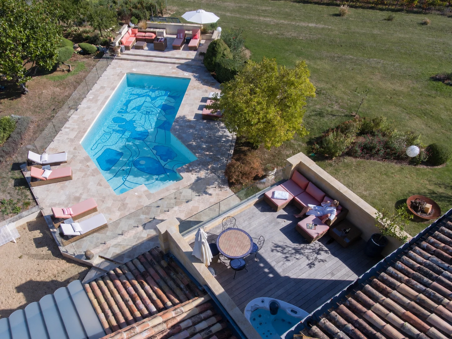 Terrasse avec transats et vue sur la piscine artistique et le vignoble